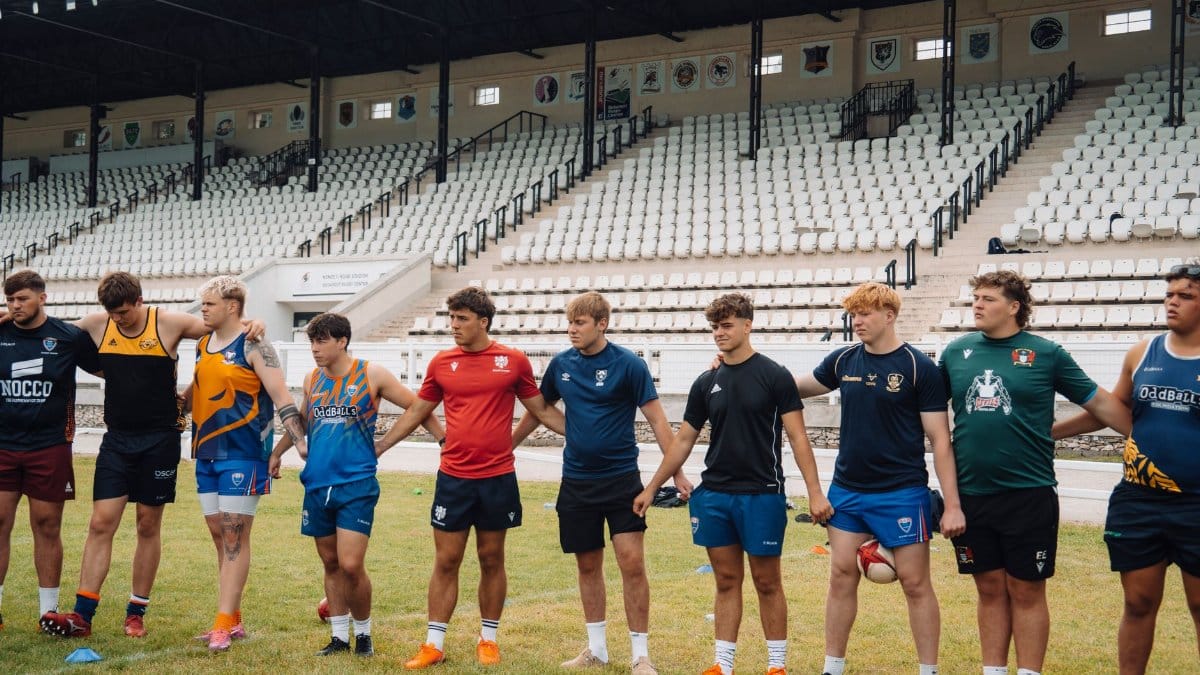 Young rugby players lined up at a Budapest stadium for a warm-up session.