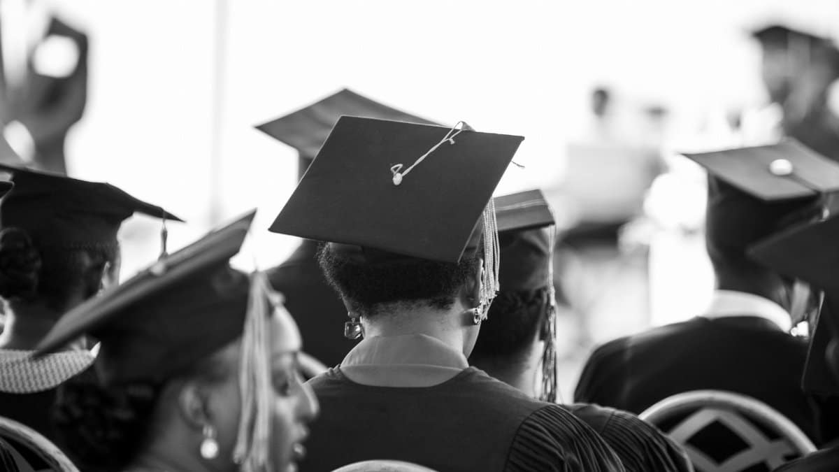 Back view of diverse graduates in caps during a ceremony.