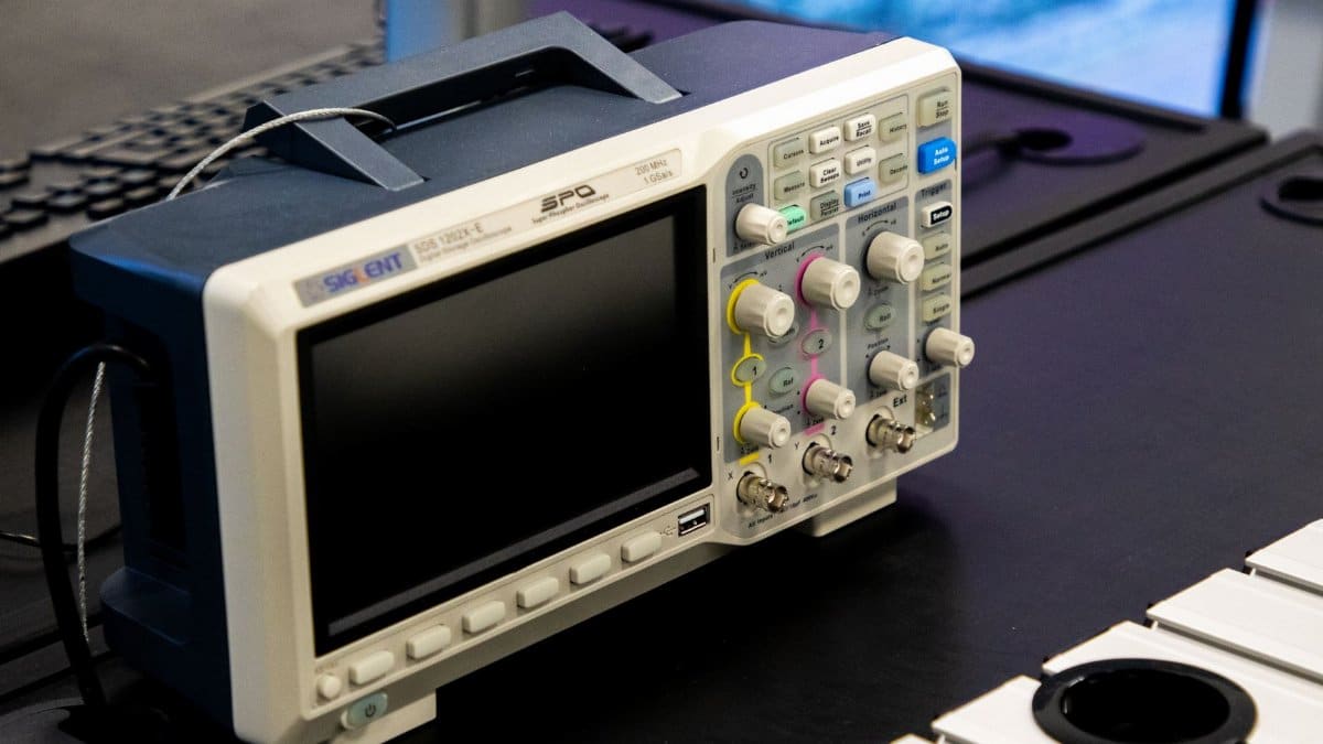A digital oscilloscope on a laboratory workbench, showcasing modern electronic equipment.