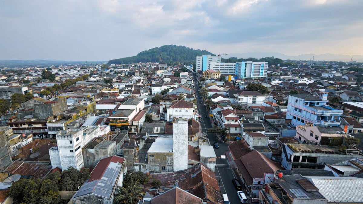 Aerial view of Salatiga cityscape in Central Java, showcasing urban landscape and distant green hills.