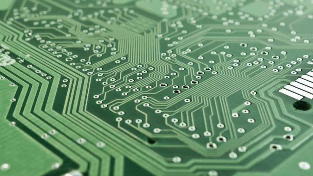 Detailed view of a green circuit board with complex patterns and pathways.