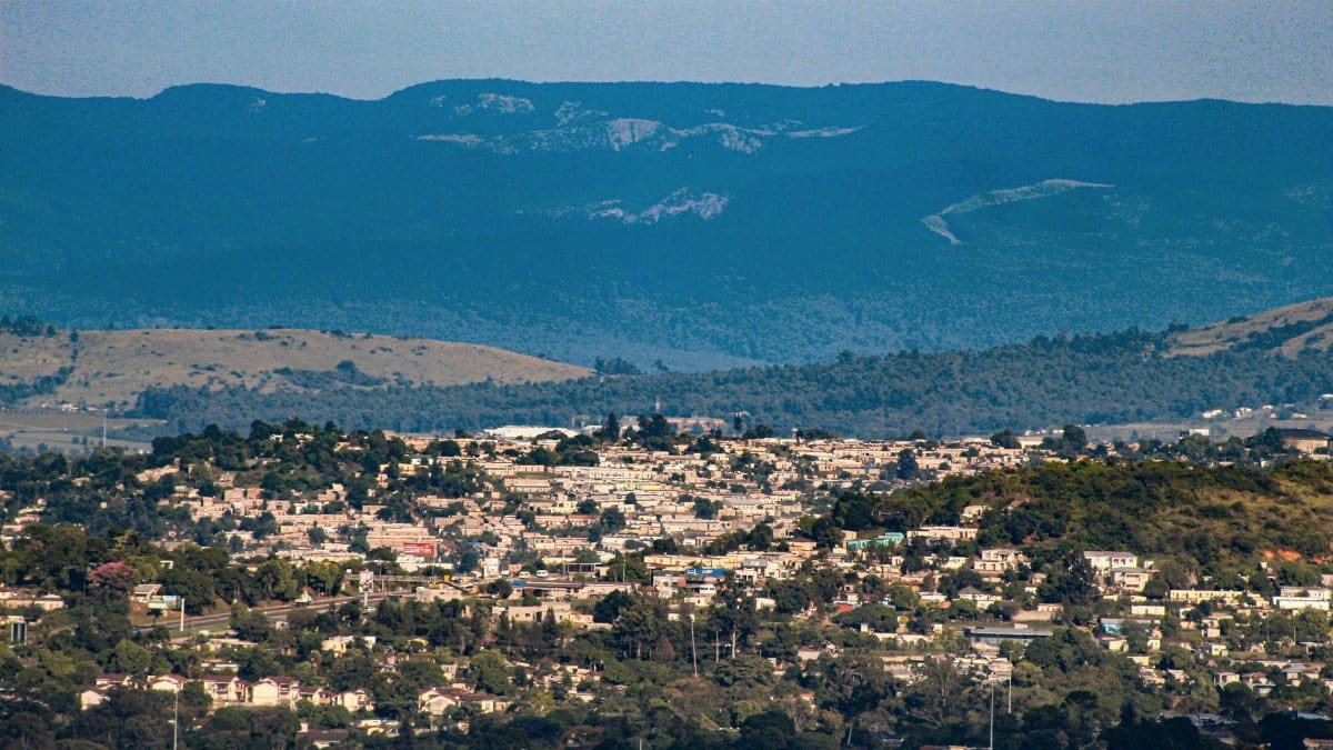 Wide view of a city in Eswatini surrounded by hills and mountains under a clear sky.