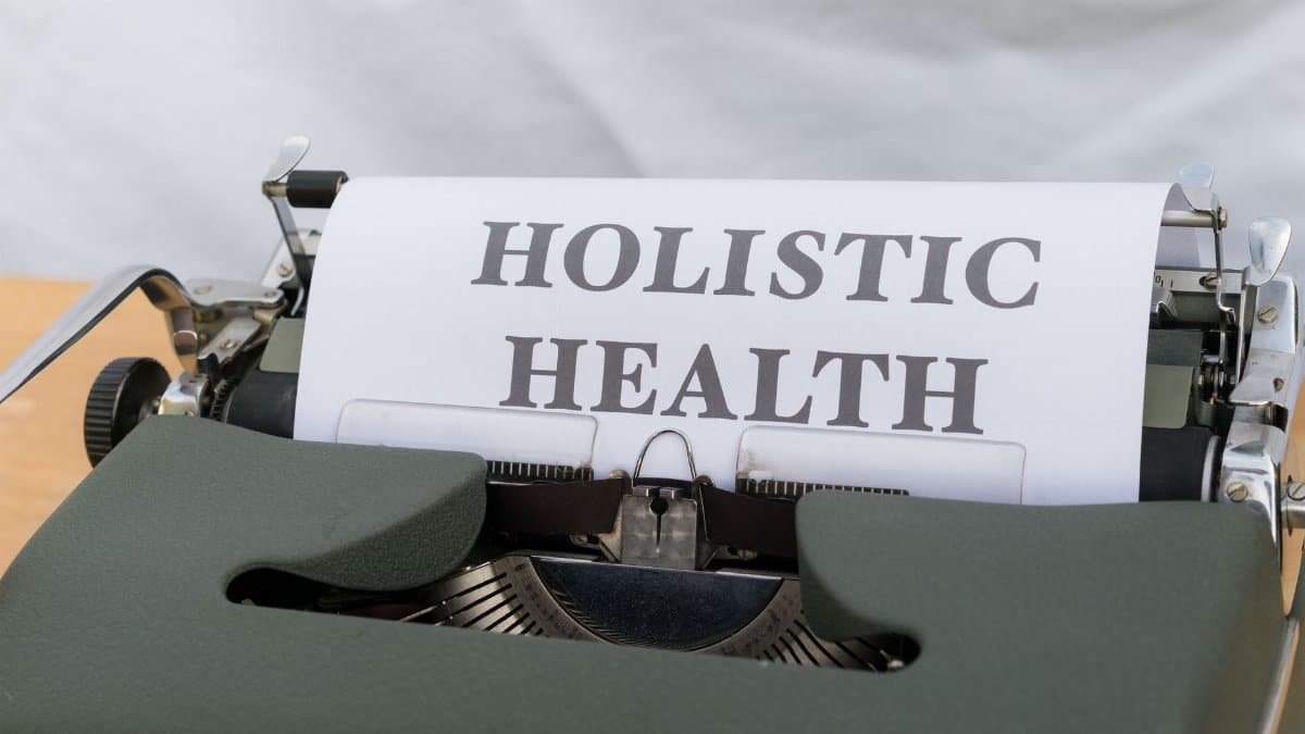 Close-up of a vintage typewriter with 'Holistic Health' typed on paper, symbolizing wellness.