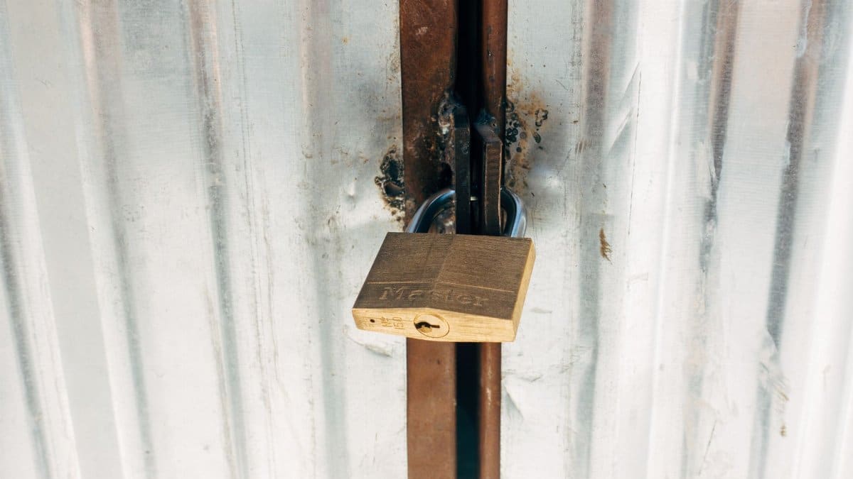A sturdy padlock securing a metallic gate, highlighting safety and security.