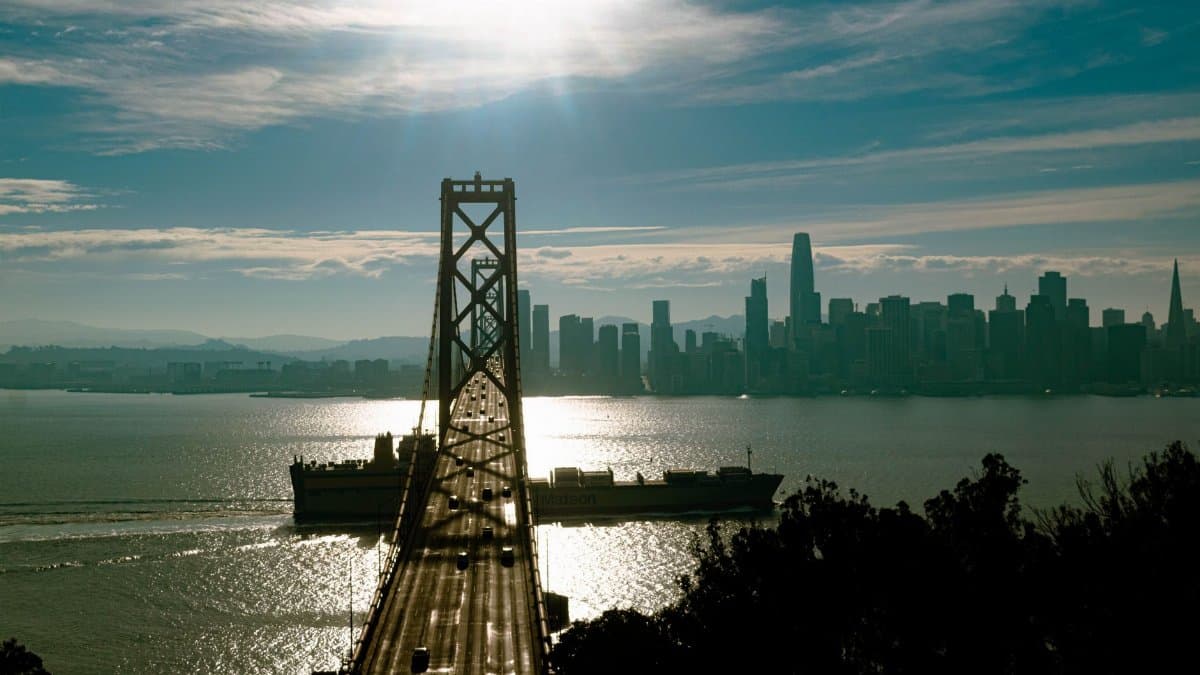A stunning view of the Golden Gate Bridge and San Francisco skyline at sunset with vibrant colors and reflections.