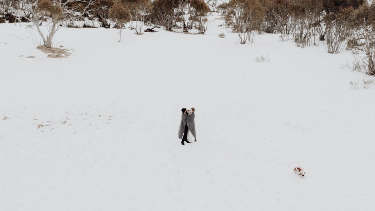 A romantic couple embracing in a snowy landscape, symbolizing love and intimacy.