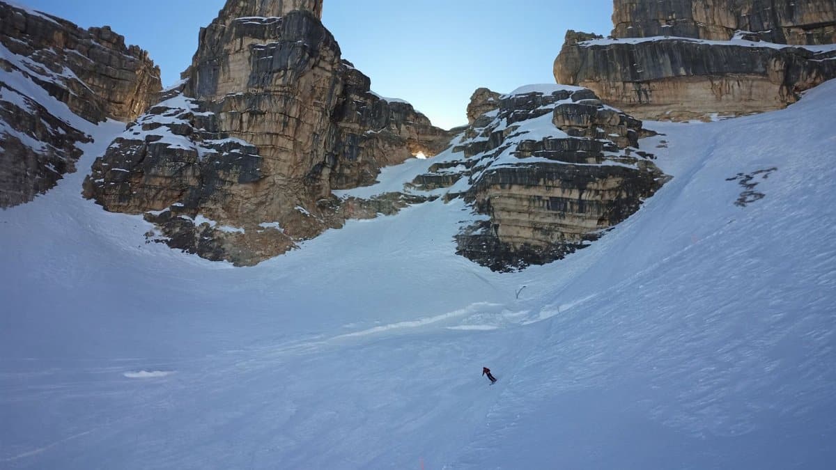 A skier descends snowy slopes in the dramatic Dolomite Mountains, Veneto, Italy.