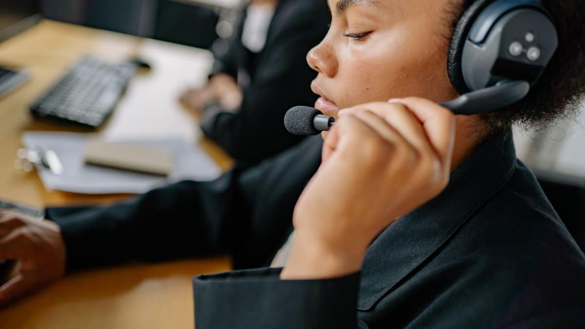 Close-up of a call center agent wearing a headset, focused on providing customer service.