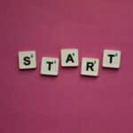 Scrabble tiles spelling 'START' against a pink background. Perfect for motivational themes.