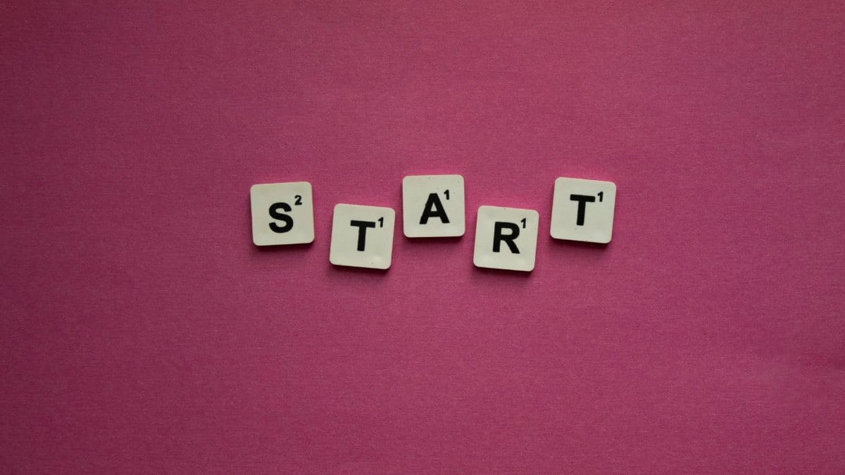 Scrabble tiles spelling 'START' against a pink background. Perfect for motivational themes.
