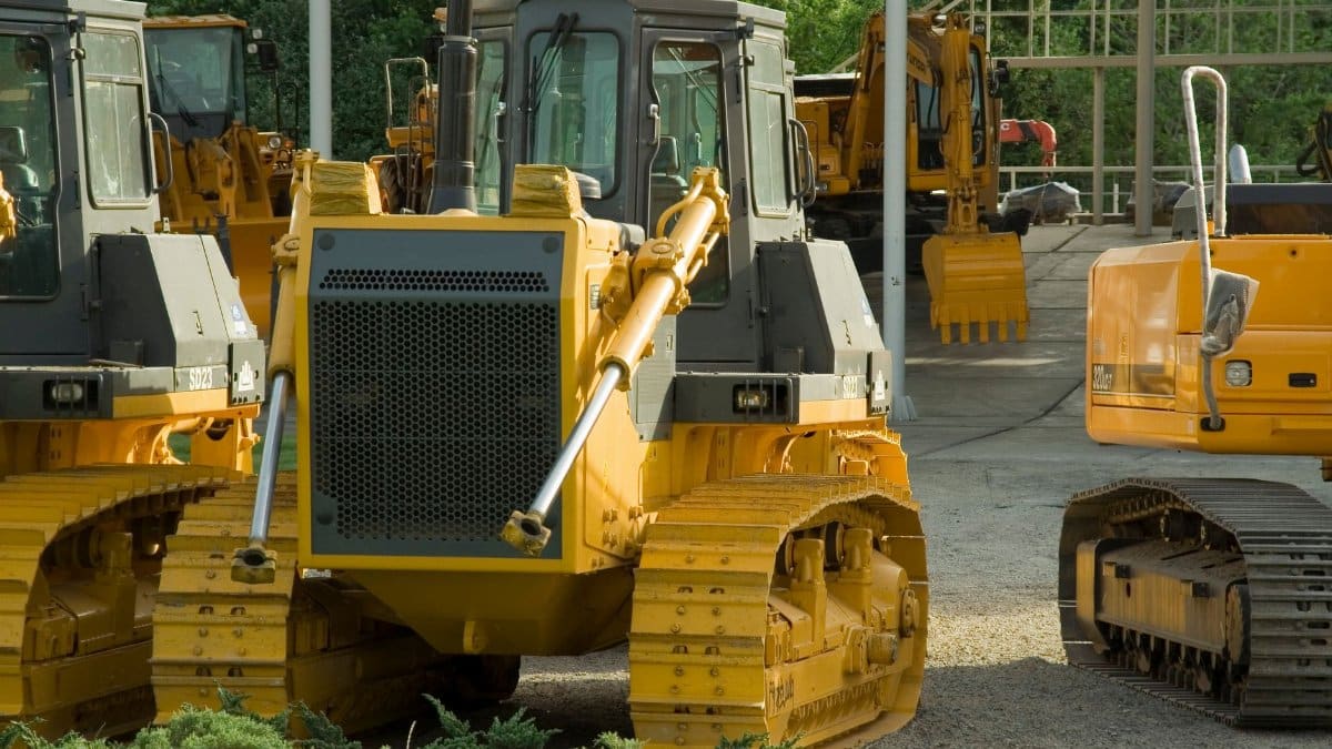 Multiple bulldozers parked in an outdoor construction area, ready for use.