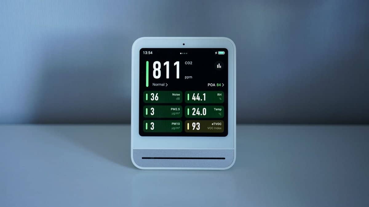 Close-up of a digital air quality monitor showing CO2 and PM2.5 levels indoors.