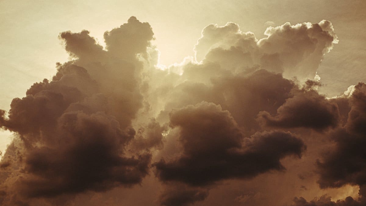 Stunning sunlit clouds create a dramatic silhouette against a golden sky, evoking tranquility.