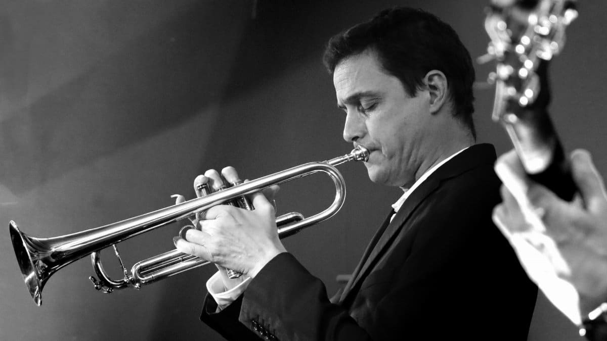 Elegant black and white photo of a trumpet player performing live at a jazz concert. Captures musical passion.
