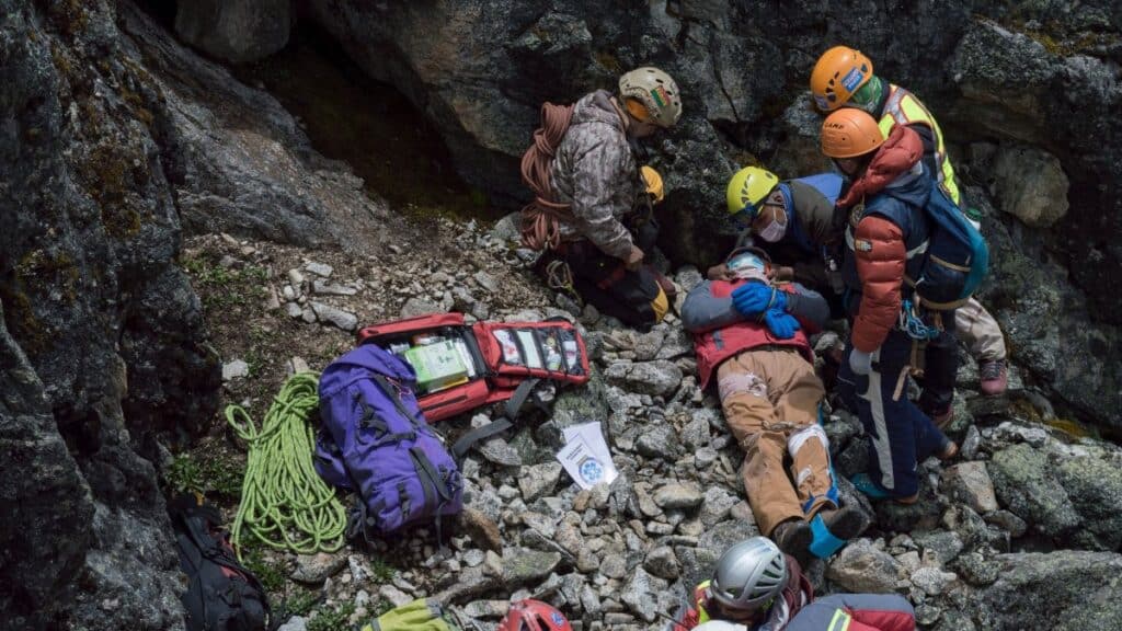 Emergency team provides aid to an injured climber during a mountainside rescue mission.