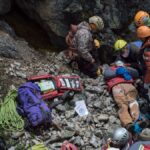 Emergency team provides aid to an injured climber during a mountainside rescue mission.