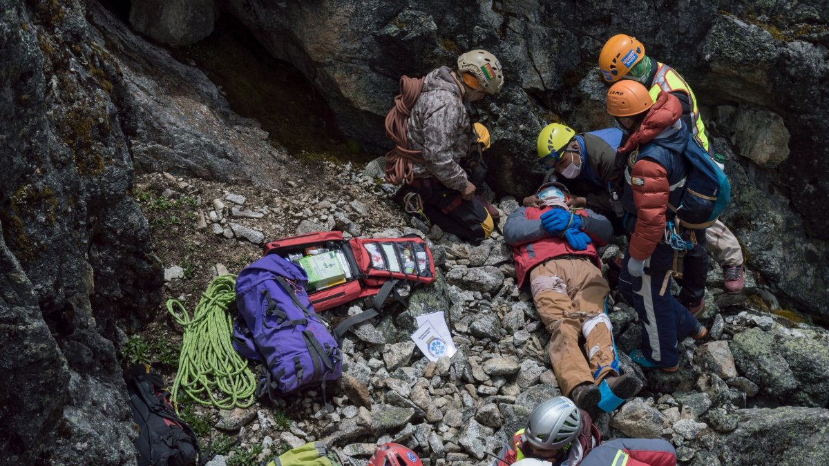 Emergency team provides aid to an injured climber during a mountainside rescue mission.