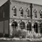 Black and white photo of a historic building in Weaver, MN with a dead-end sign.
