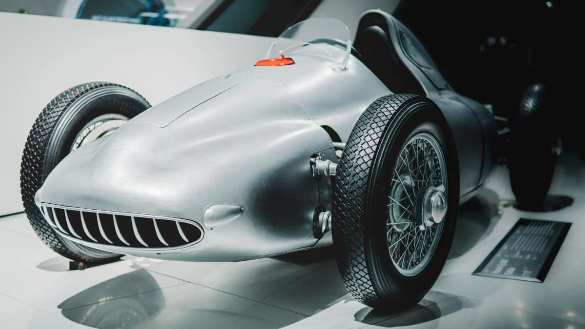 Vintage race car on display in a modern museum setting. Ideal for historical automotive concepts.