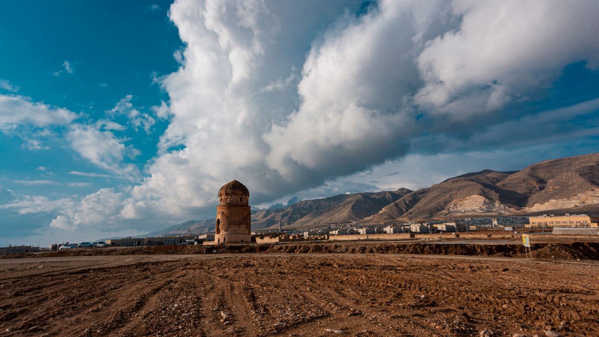 Stunning view of a historic tower in Hasankeyf, Türkiye, under a dramatic blue sky.