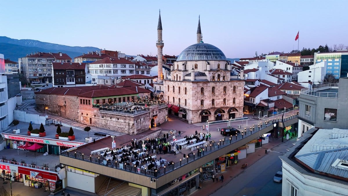 Aerial shot of Bolu city with a prominent mosque and bustling streets during twilight.