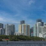 Stunning view of Miami's skyline over Biscayne Bay with clear skies and lush greenery.