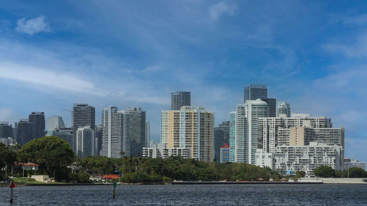 Stunning view of Miami's skyline over Biscayne Bay with clear skies and lush greenery.