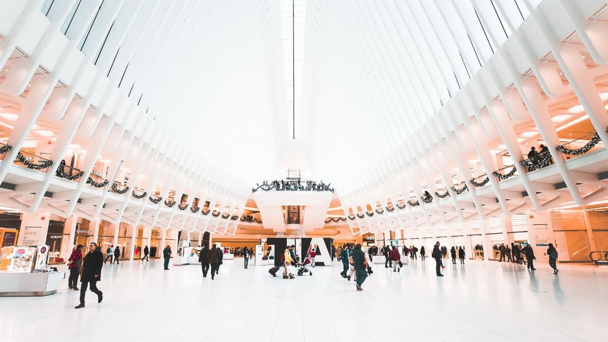 Wide angle of crowd of people in casual clothes walking along modern spacious hall in Freedom Tower in bright daylight