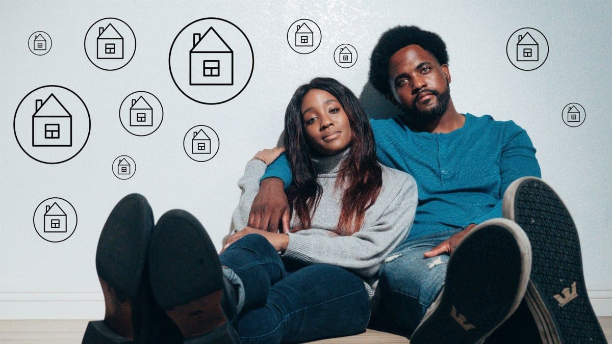 Couple sitting on the floor dreaming about new home ownership surrounded by house icons.