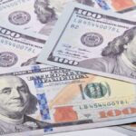 High-quality image of US $100 bills scattered on a white surface. Ideal for financial themes.