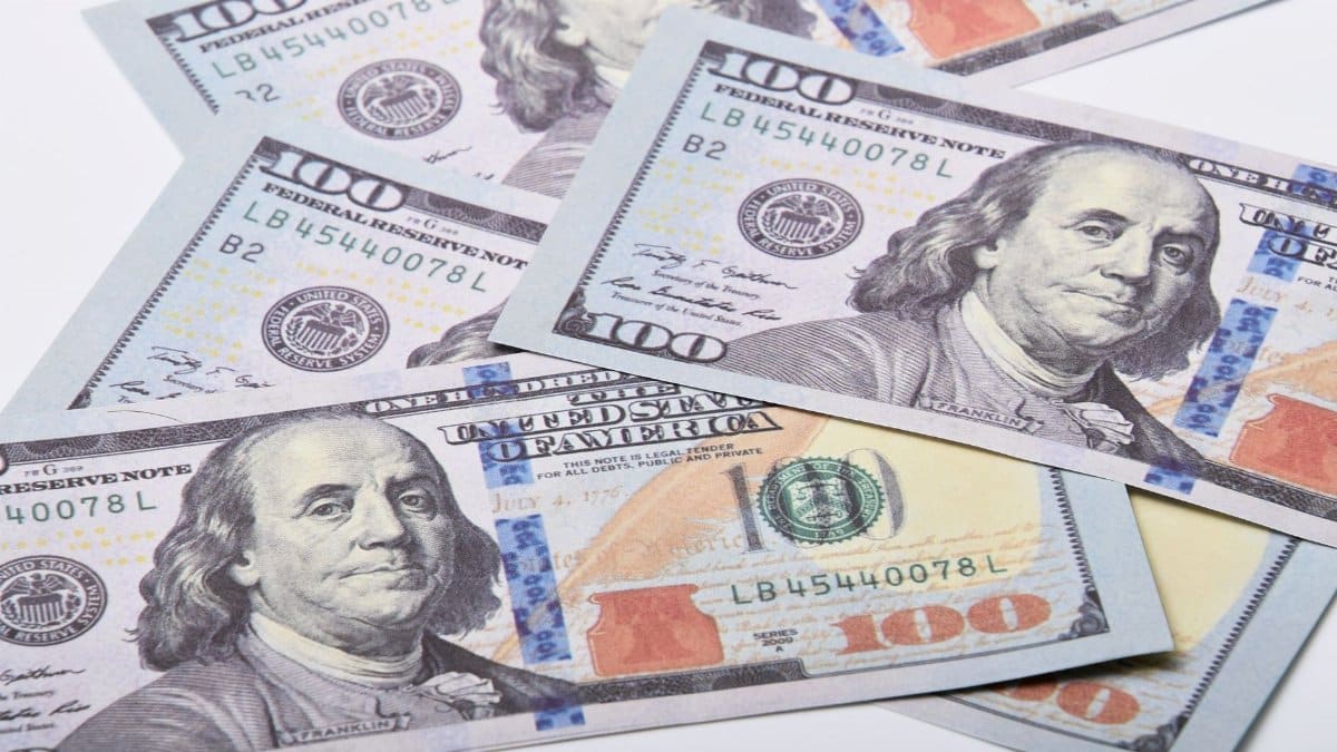High-quality image of US $100 bills scattered on a white surface. Ideal for financial themes.