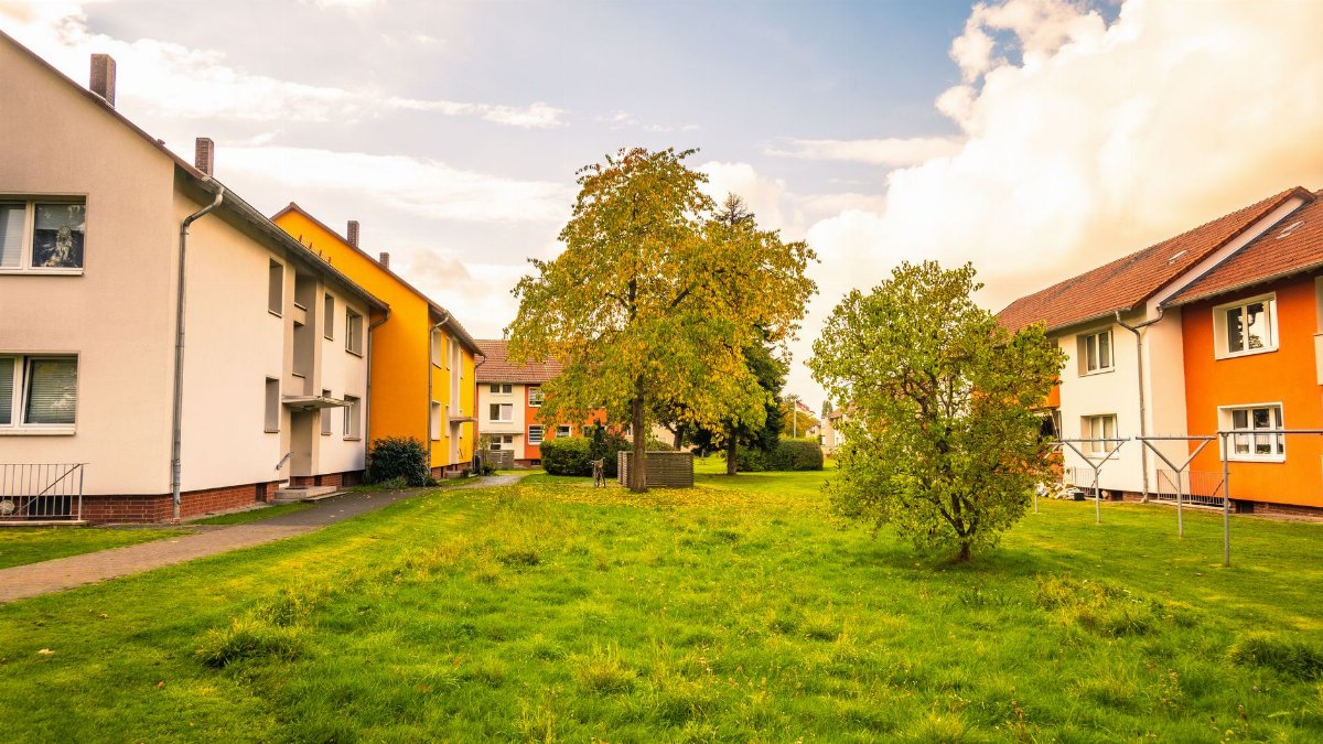 Cozy autumn view of colorful residential buildings and lush greenery in Niedersachsen, Germany.
