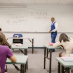 A college educator proctoring an exam, enforcing no cheating rules.