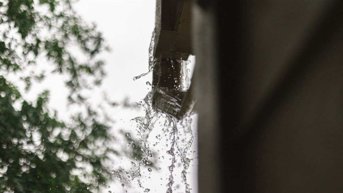 Close-up of rainwater pouring from a gutter, captured during a rainfall in Houston.