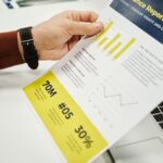 Person analyzing finance report with graphs at desk, ideal for business concepts.