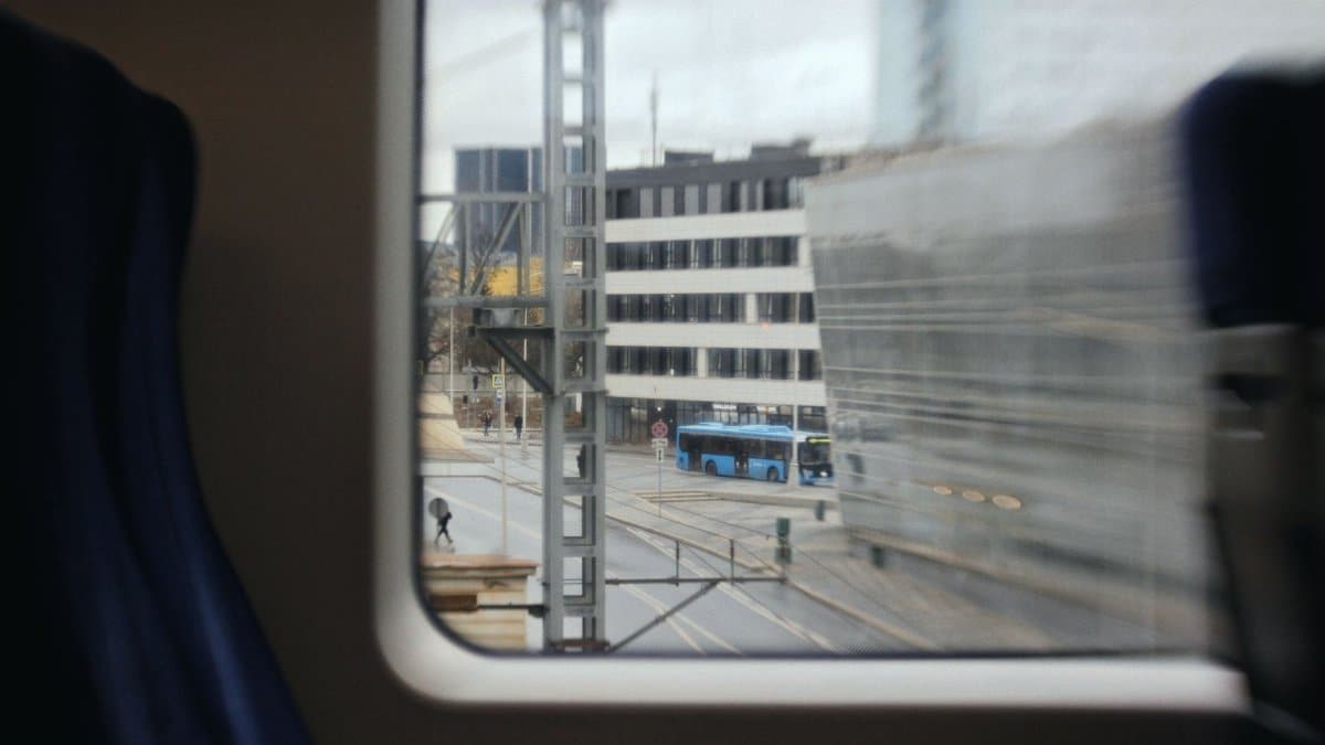 Blurred view of city street with public transport from a moving train in Moscow.