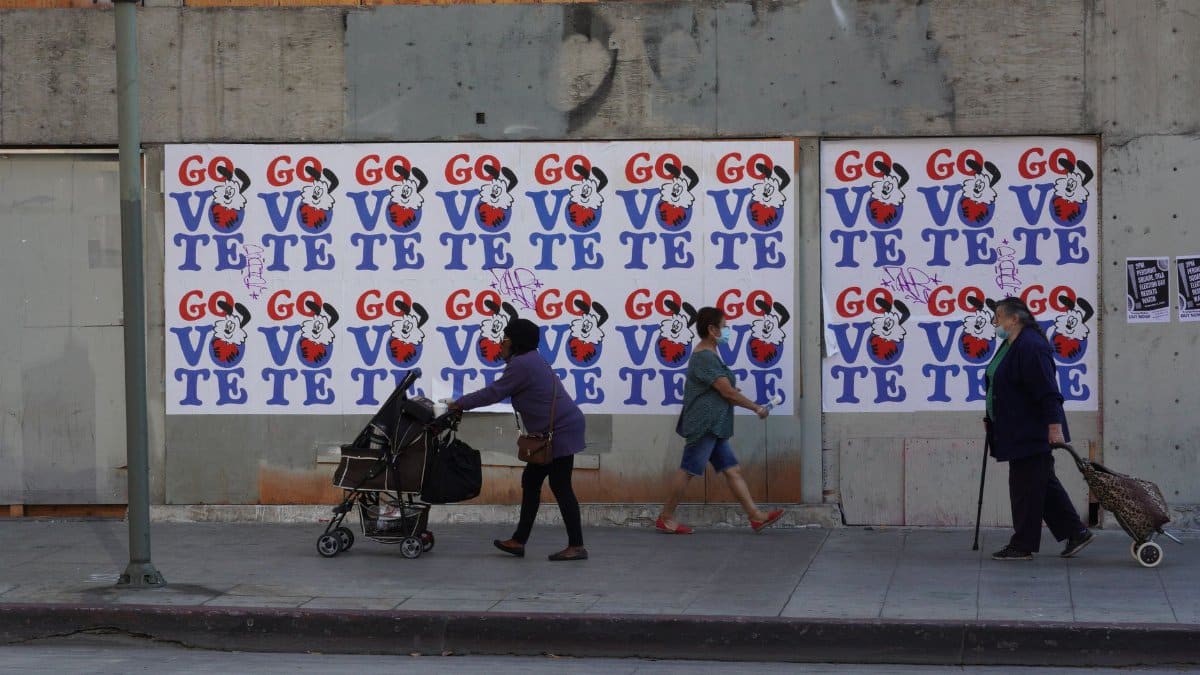 People passing Go Vote posters in Los Angeles emphasizes civic engagement.