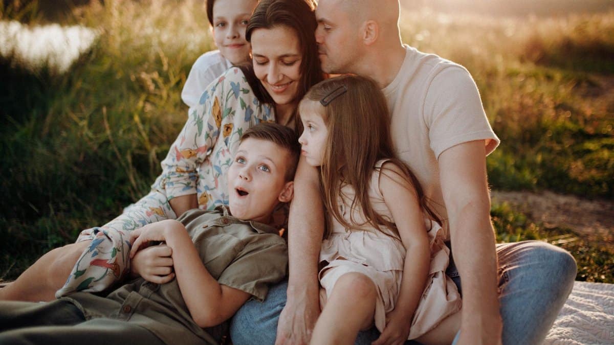 A joyful family enjoying quality time together on a sunset-lit meadow.