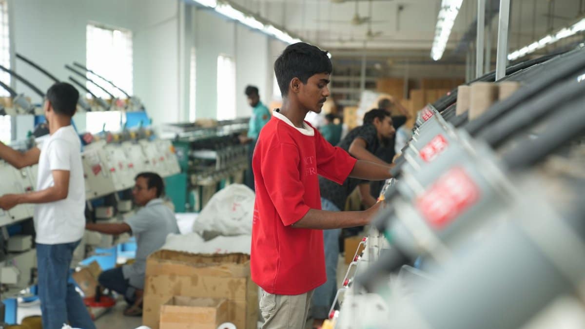 Workers in a textile factory operating machinery, focusing on production efficiency.