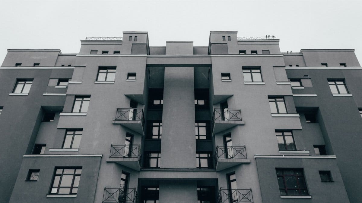 Low-angle view of a minimalist apartment facade, showcasing modern architectural design and symmetry.