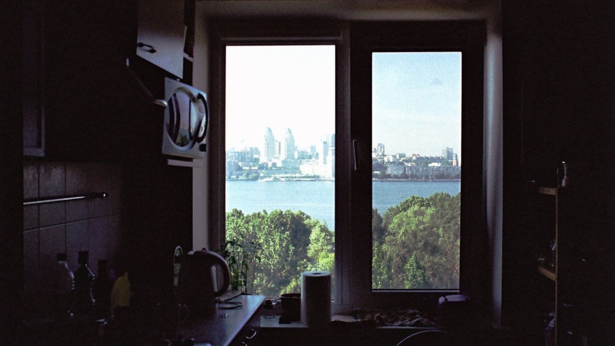 Scenic view of Dnipro city skyline and river through a kitchen window, creating a cozy vibe.