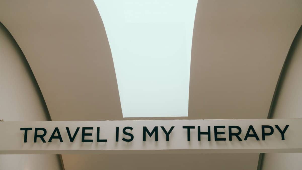 A motivational travel quote displayed in a minimalist interior setting.