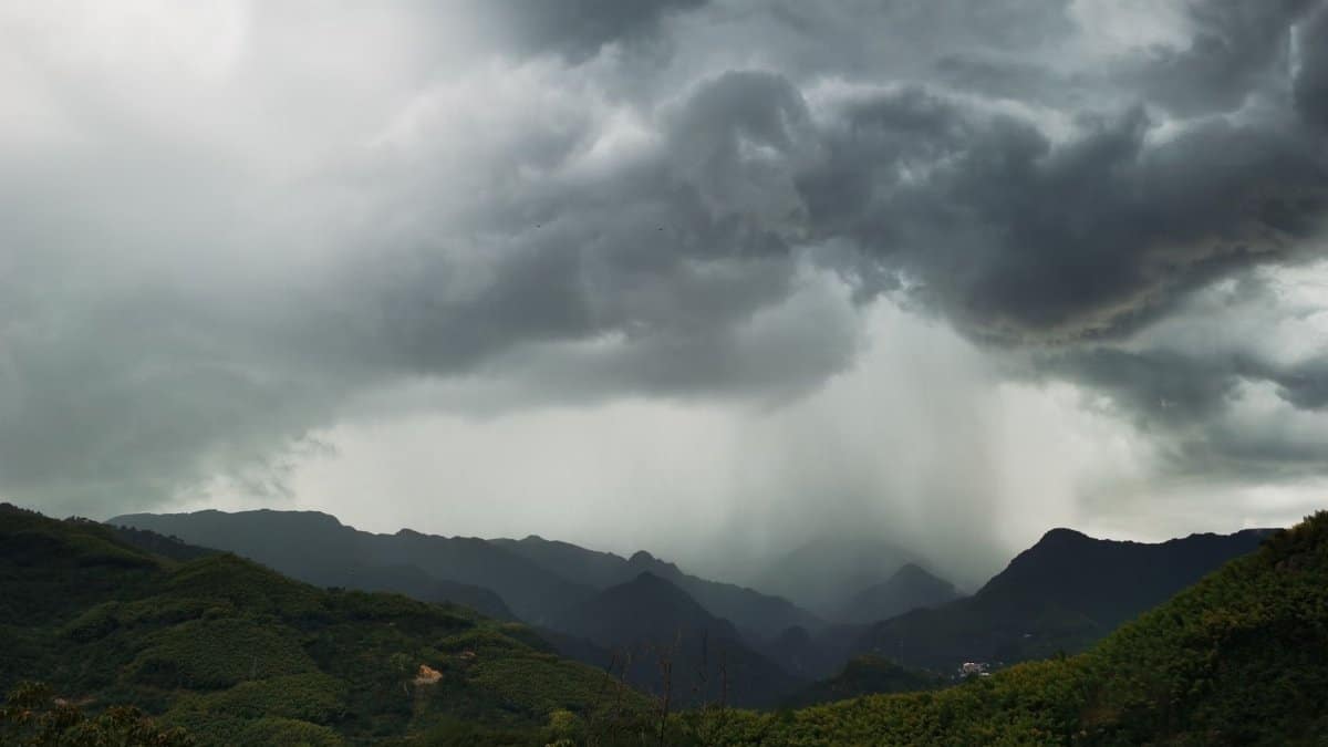 A breathtaking view of dramatic rain clouds over lush green mountains in Hangzhou, China.