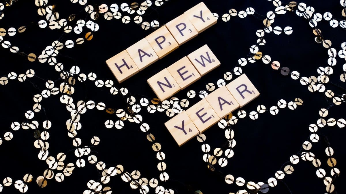 Scrabble tiles spell out 'Happy New Year' with festive decorations in Paris, France.
