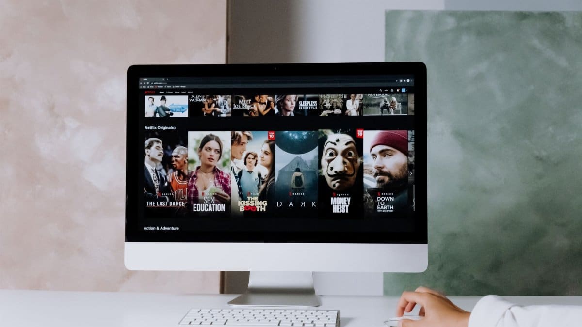 A modern workspace featuring a desktop screen displaying popular streaming series on Netflix.