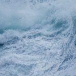 Close-up of powerful ocean waves crashing with intense seafoam and splashes.