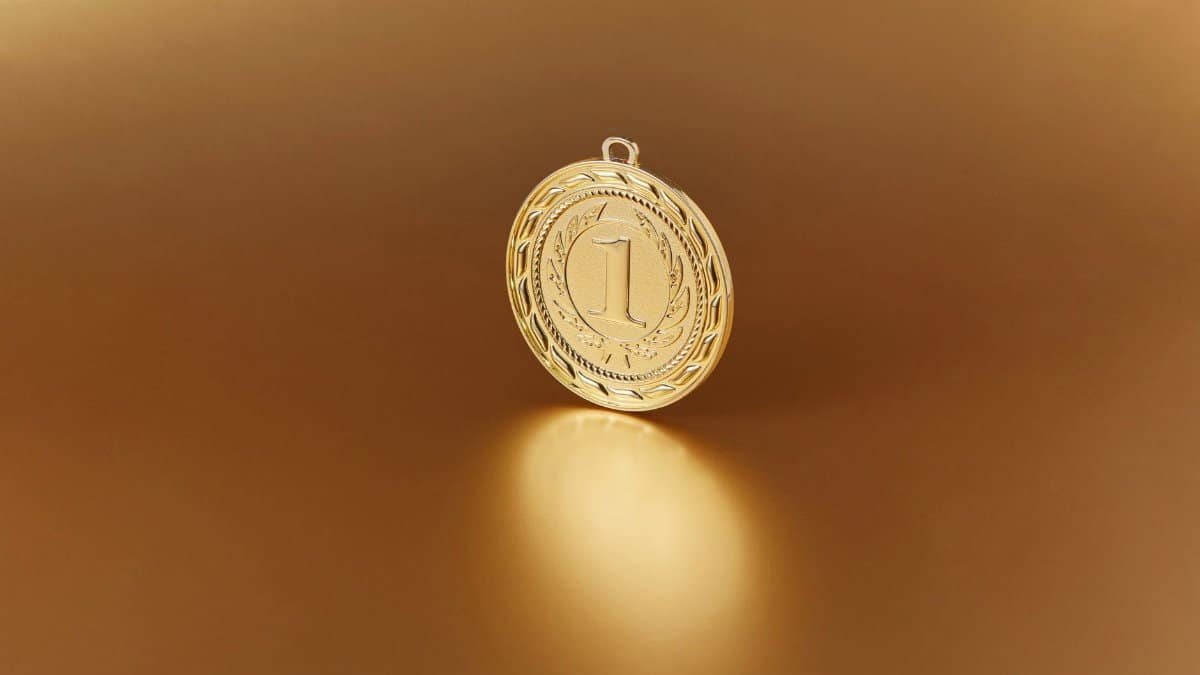 Close-up image of a golden number one medal on a soft golden background.