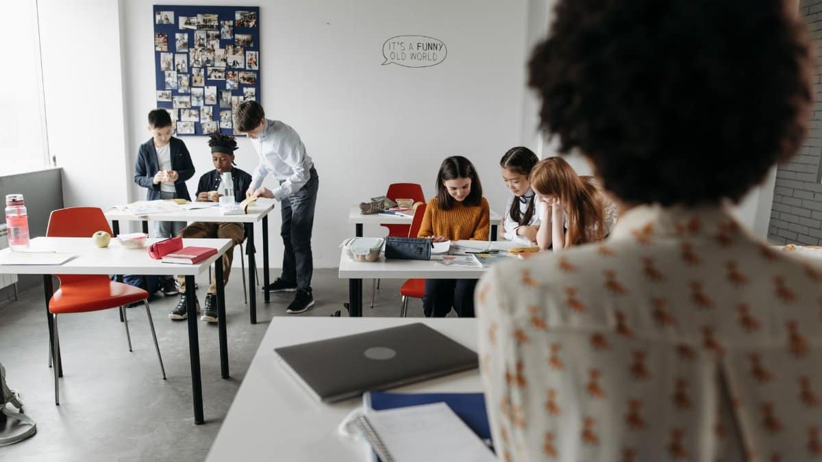 Students focused in a modern classroom with diverse activities and interactions.