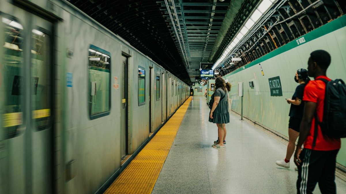 People waiting on a subway platform as a train arrives, capturing daily commute life.