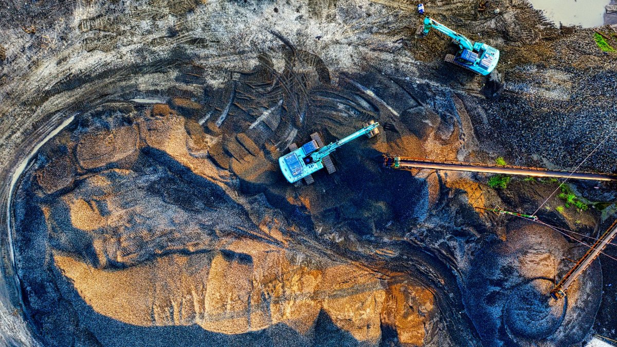 Aerial shot of an active mining site with machinery in Banten, Indonesia.
